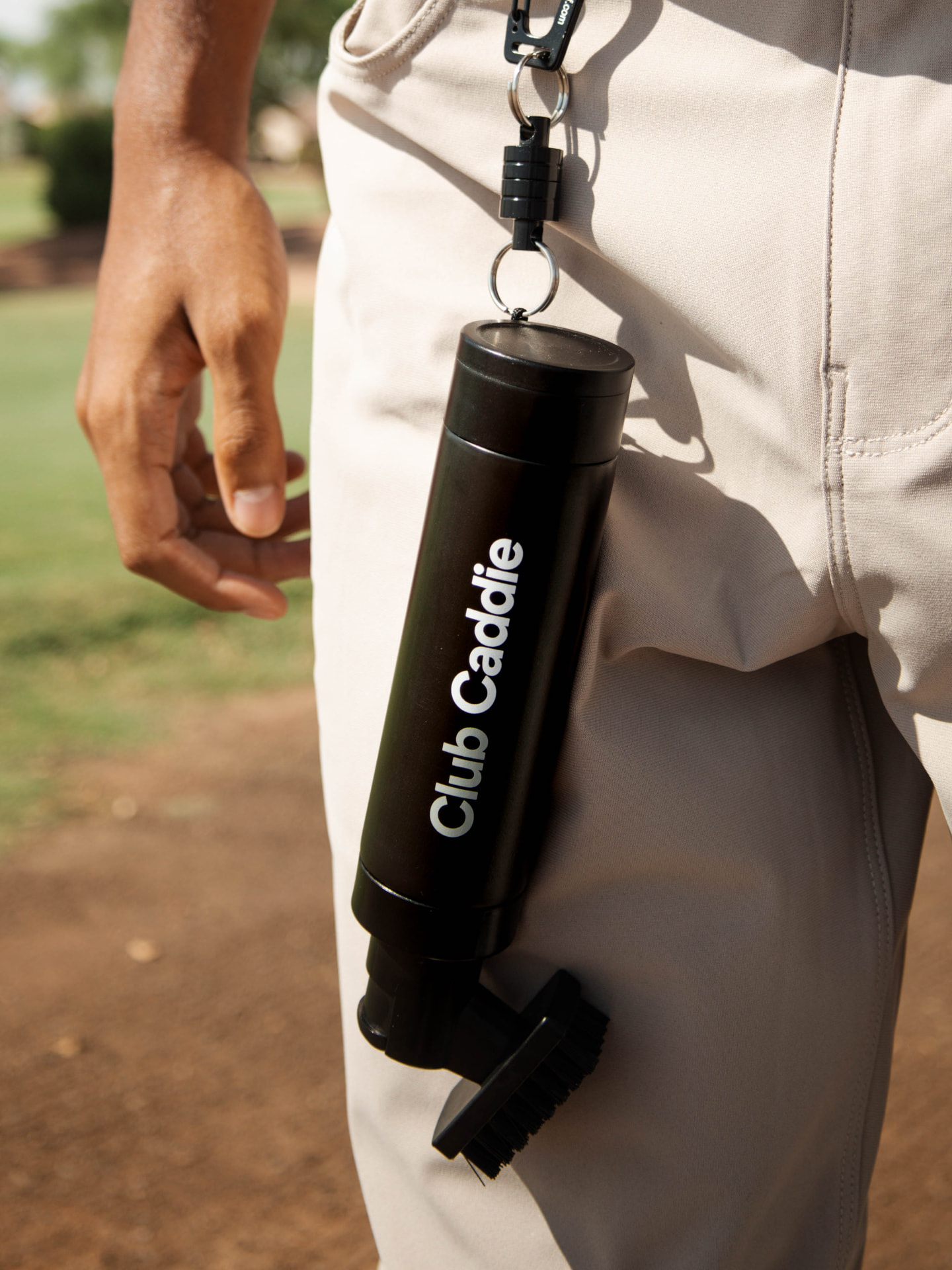 Club Caddie Brush clipped to a golfer's belt loop